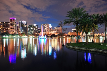 orlando downtown skyline over lake eola at dusk with urban skyscrapers and lights.